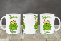 Kubek z nadrukiem zielonej żaby z koroną i czerwonymi ustami oraz napisem Zajebista Kasia