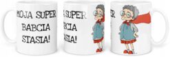 Biały kubek z napisem Moja Super Babcia Stasia oraz rysunkiem babci z czerwonym płaszczem i okularami