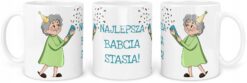 Kubek z napisem Najlepsza Babcia Stasia i ilustracją starszej kobiety w zielonej sukience z czapeczką imprezową